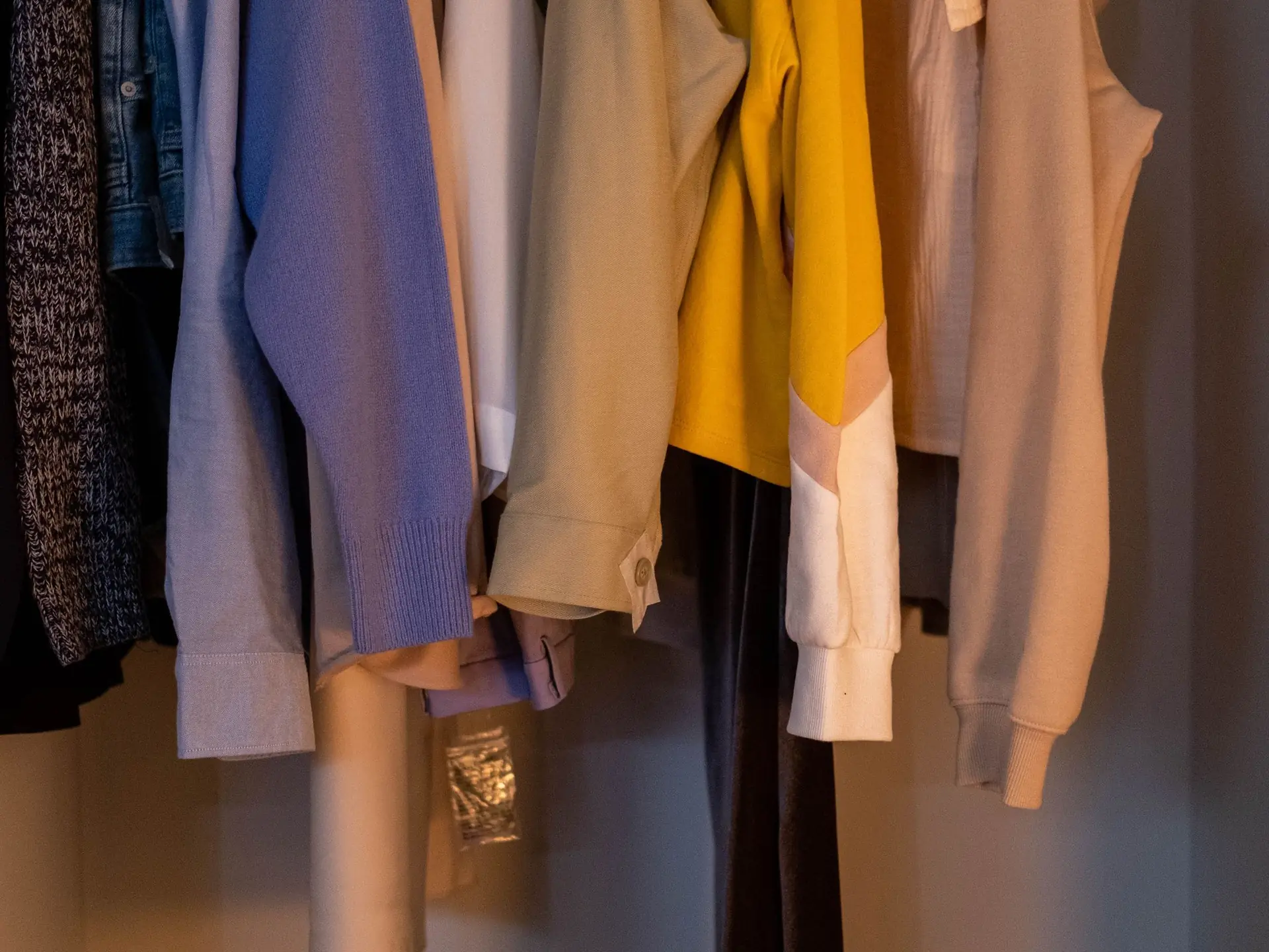 Clothes hanging inside a wooden wardrobe