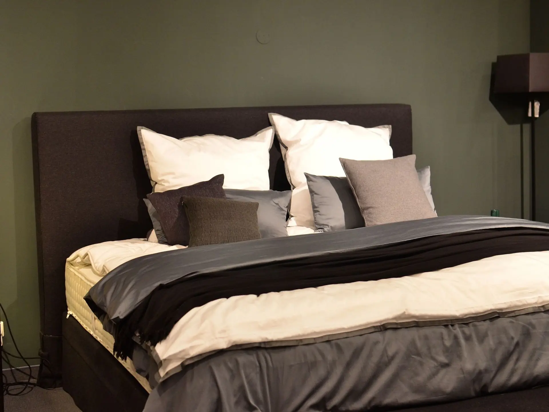 Made bed with layered pillows in a modern bedroom