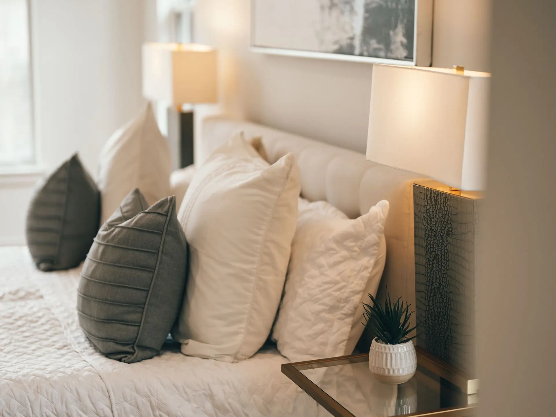 Bed with framed artwork and wall lamps above the headboard