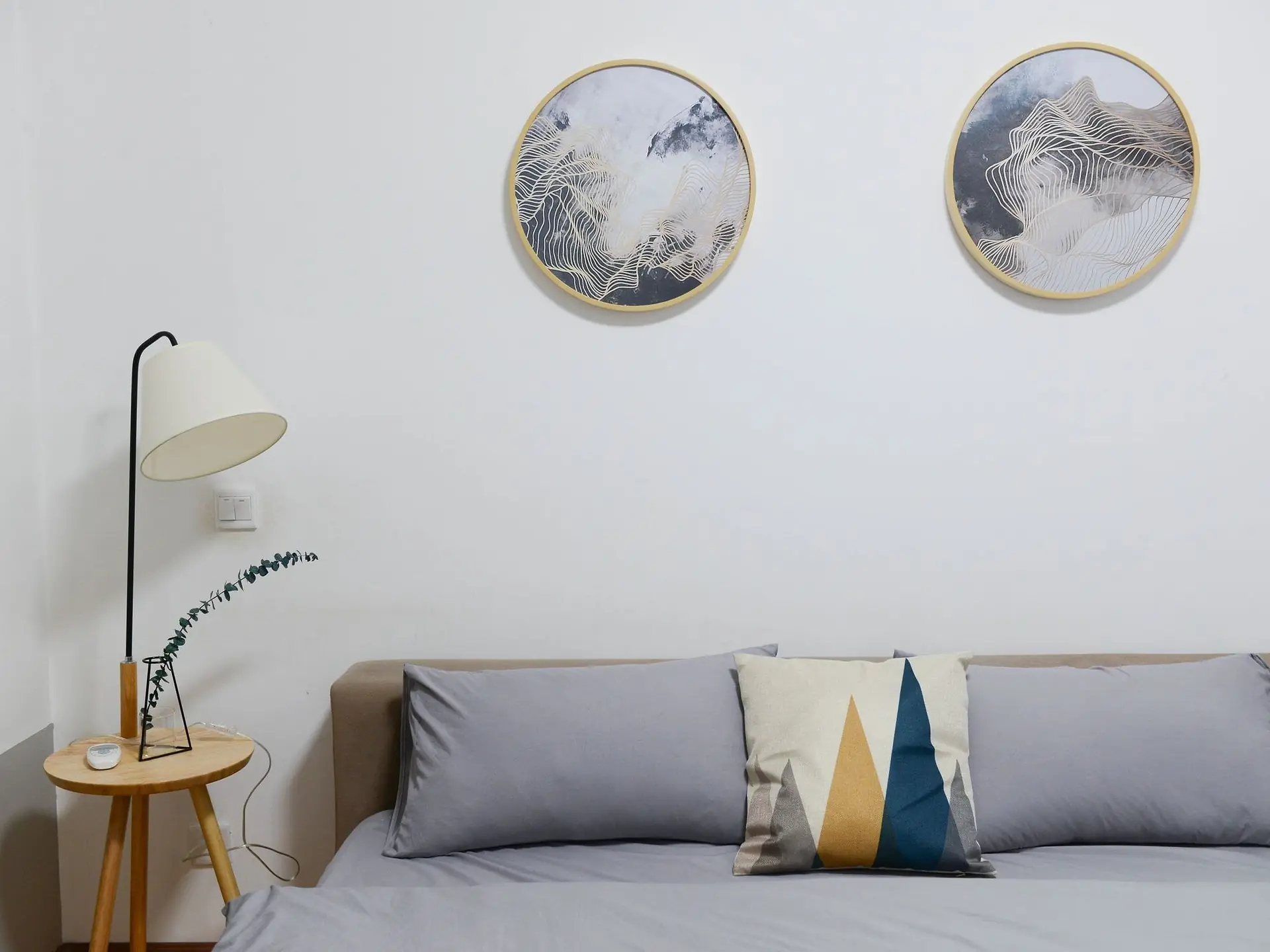 Wooden nightstand with a lamp beside a bed