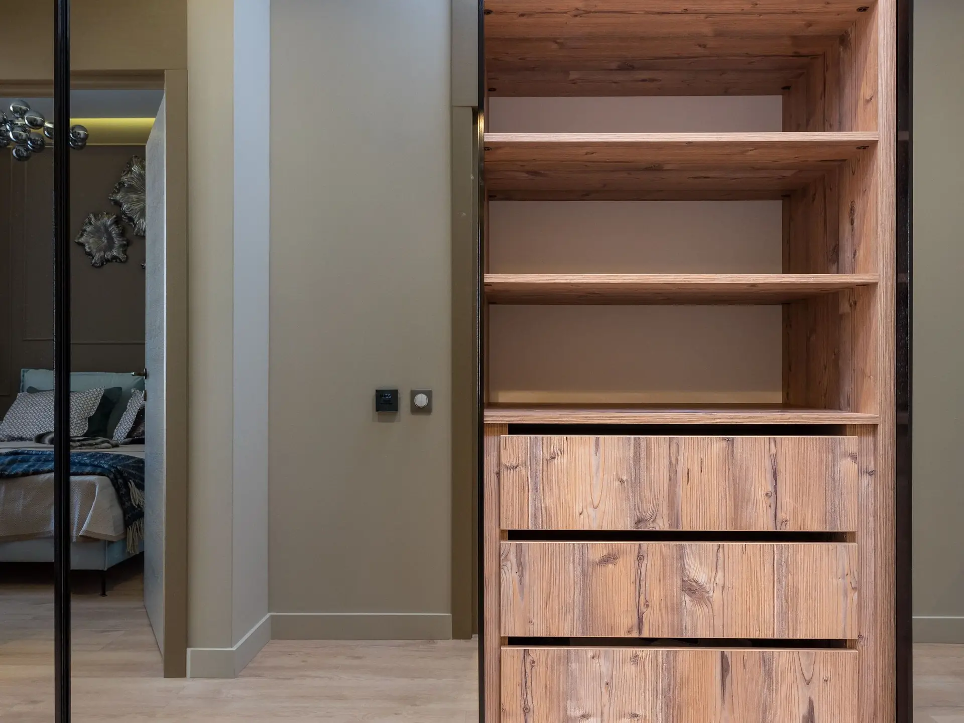 Wooden cabinet with shelving beside a bed