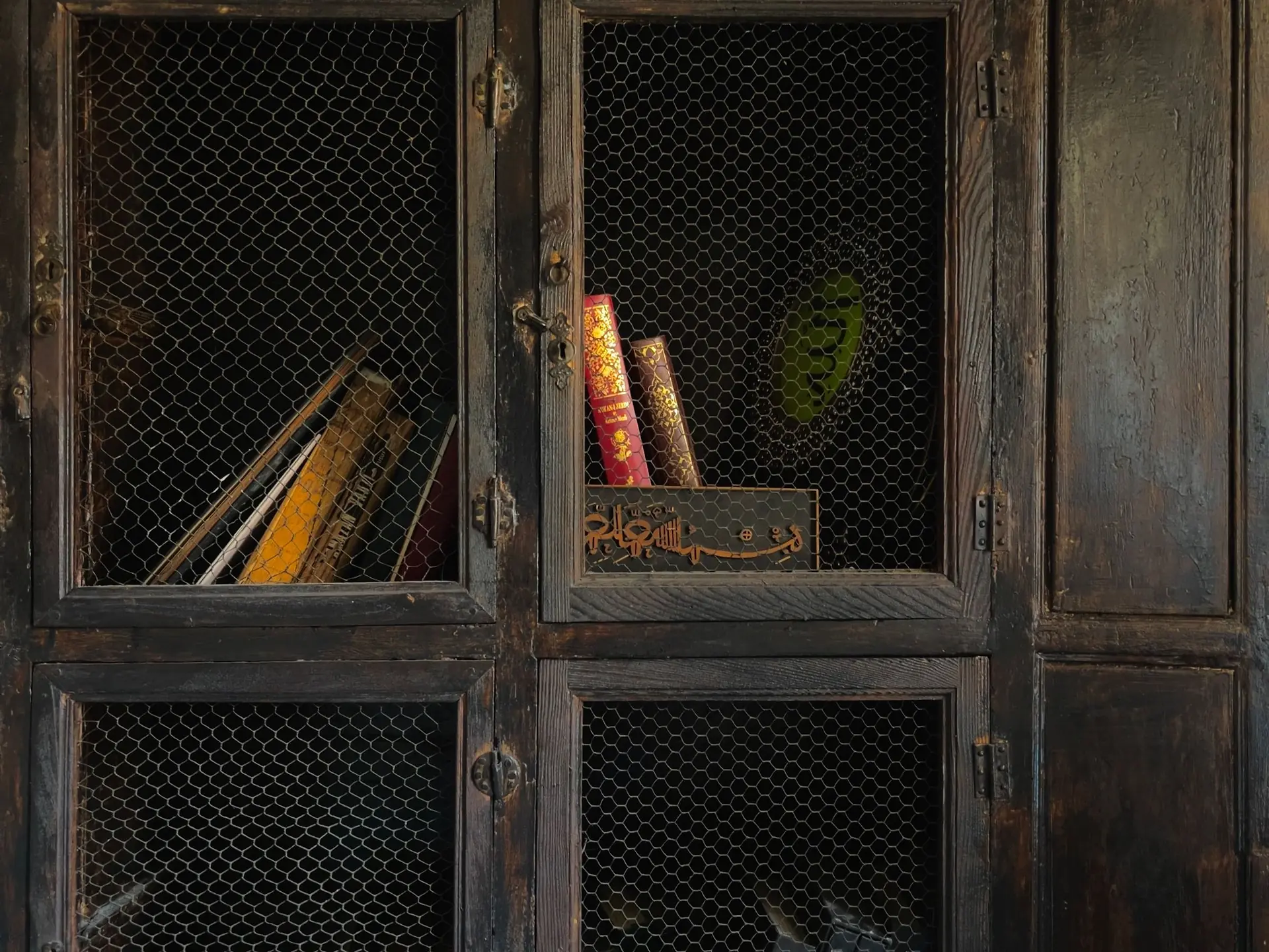 Wooden cabinet holding books and objects