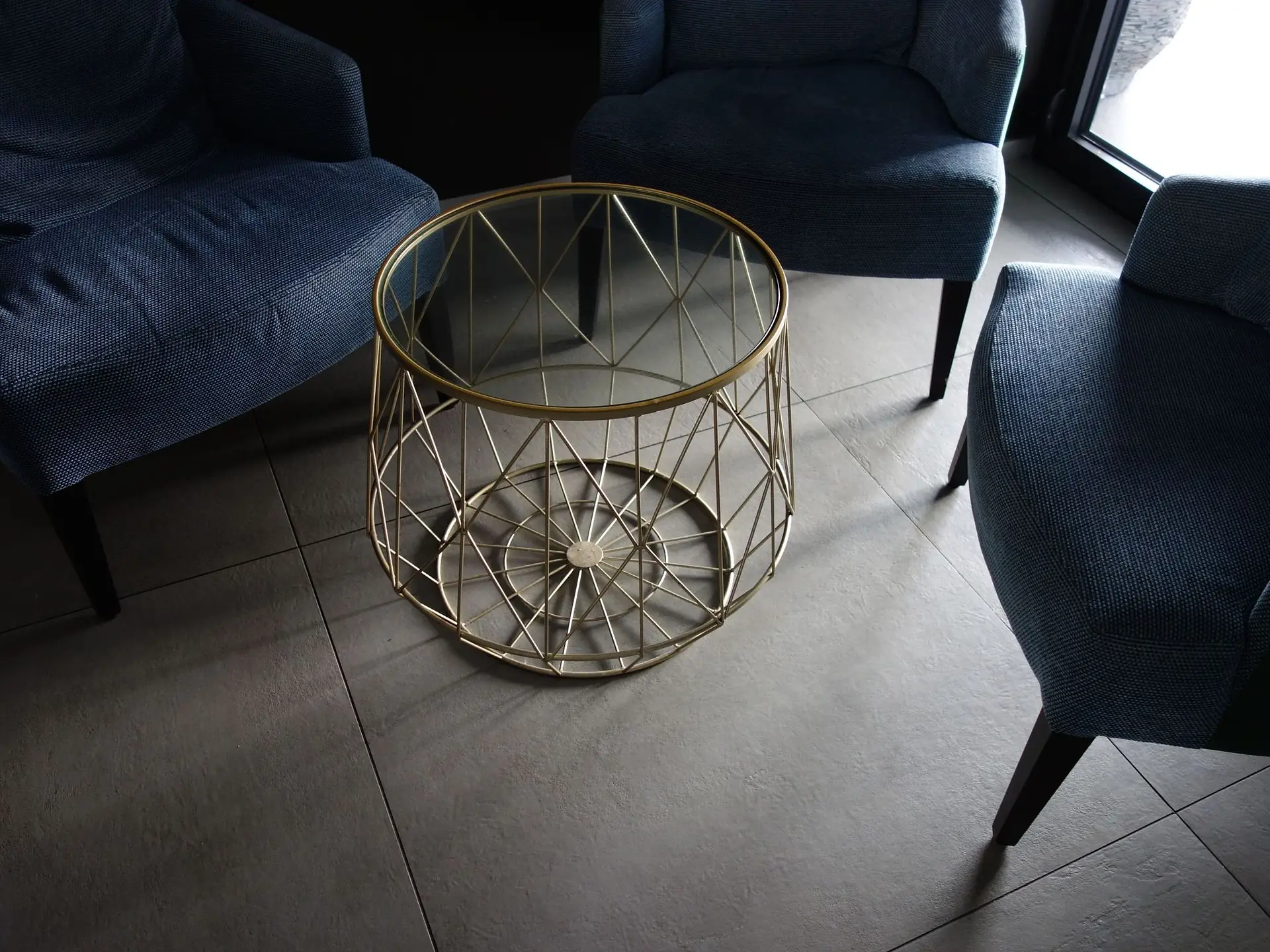 Blue armchairs around a glass-topped table