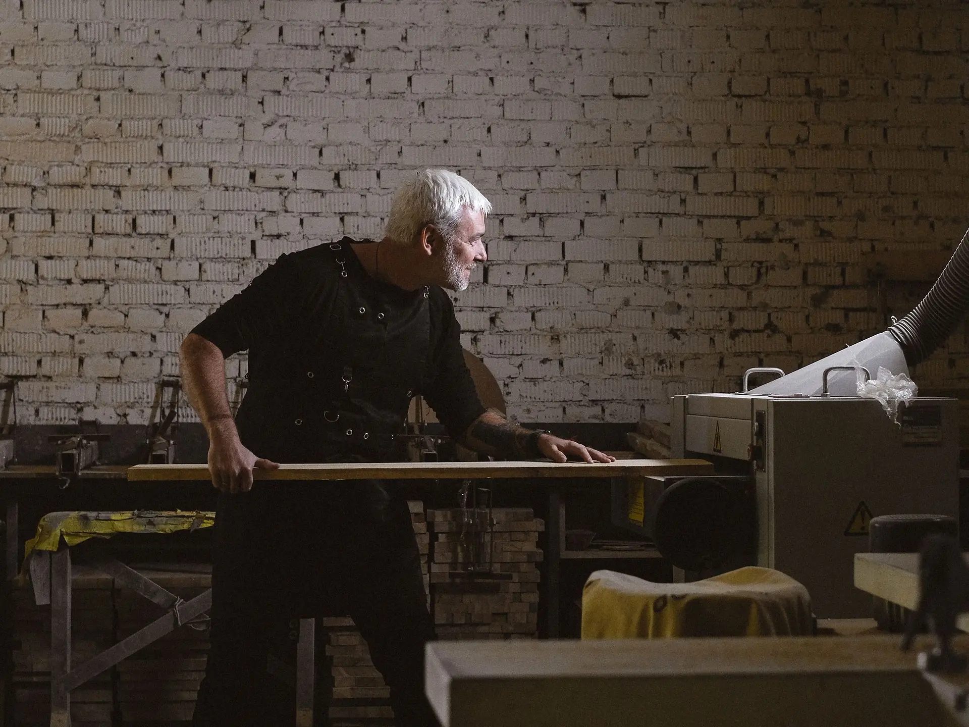 Craftsman running a furniture component through a planing machine