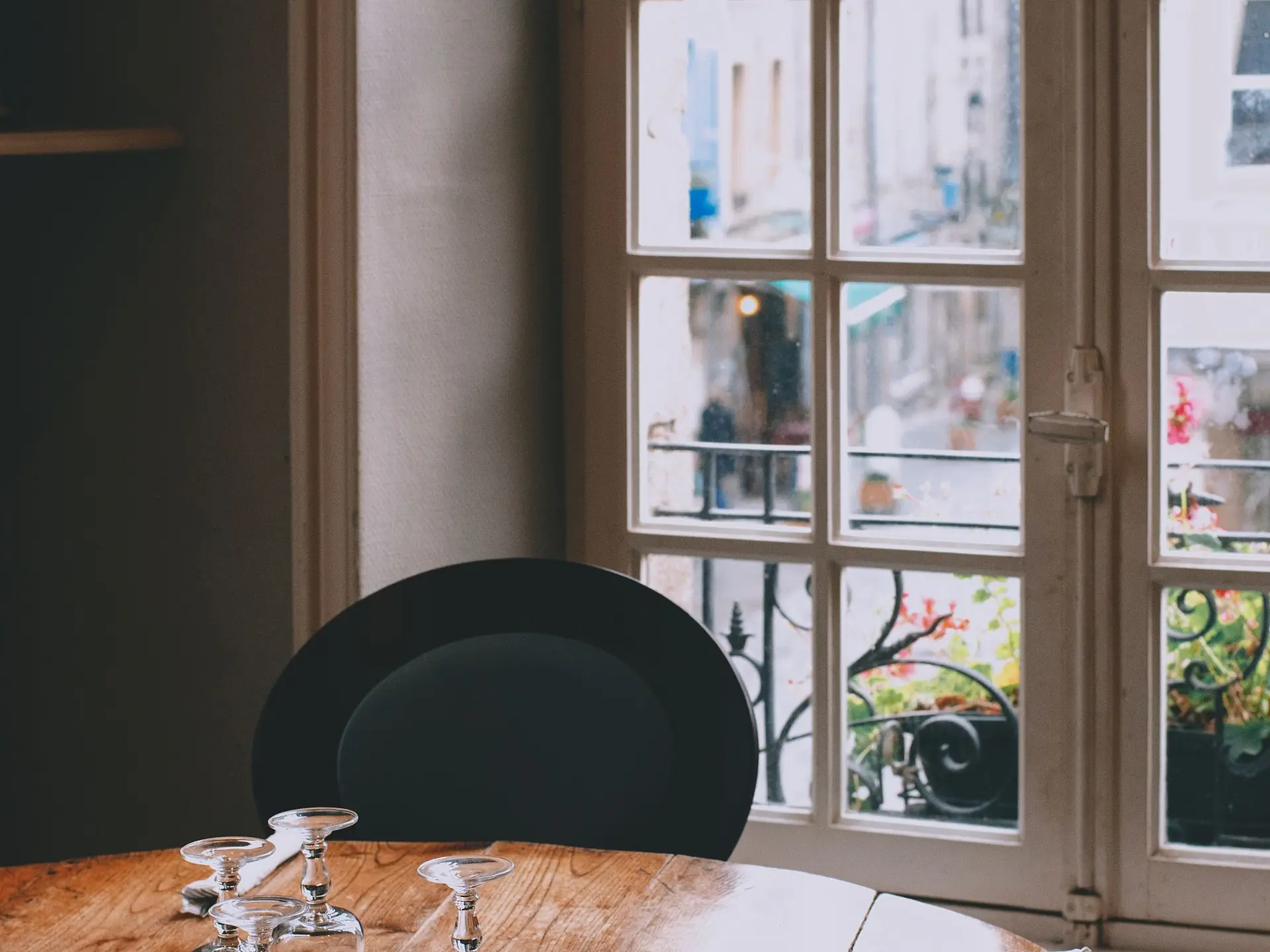 Round dining table with glassware beside a window