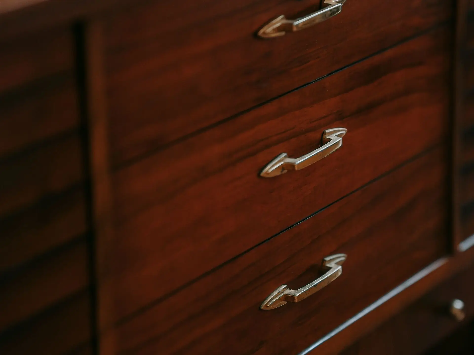 Wooden dresser with metal handles in a bedroom